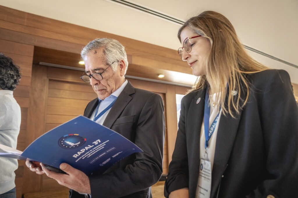 Dos asistentes miran la carpeta de la XXXVII RAPAL durante el encuentro en Ushuaia