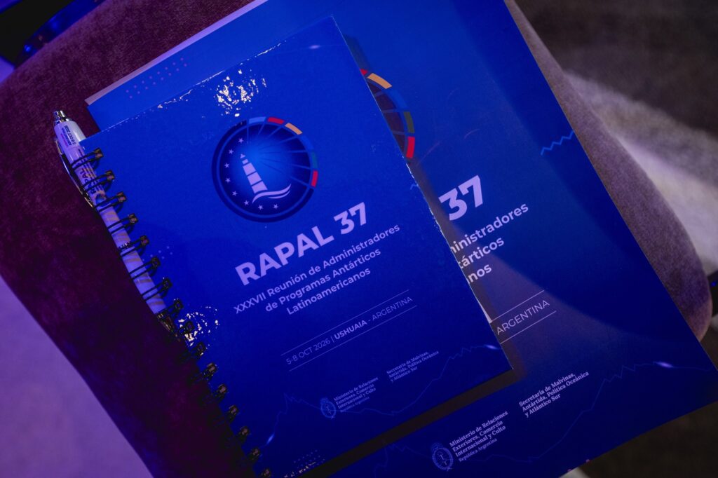 Cuadernos de la XXXVII RAPAL con el logo del faro y la fecha, del 5 al 8 de octubre de 2026 en Ushuaia, junto a una lapicera