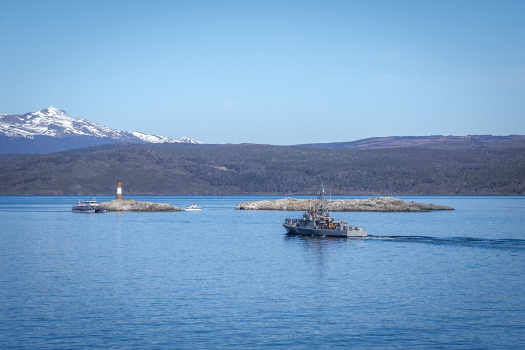 Faro Les Eclaireurs y un buque gris en el Canal Beagle, vistos desde el buque durante la navegación